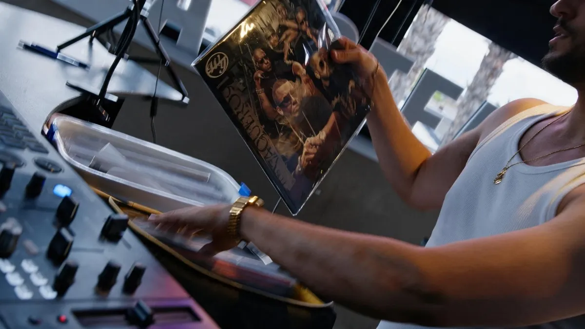 DJ con un vinilo en la mano, en la cabina de los platos